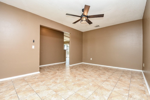 tiled empty room featuring a textured ceiling and ceiling fan