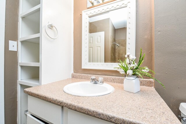 bathroom featuring built in features, vanity, and toilet