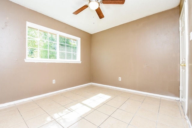 spare room featuring light tile patterned floors, ceiling fan, and baseboards