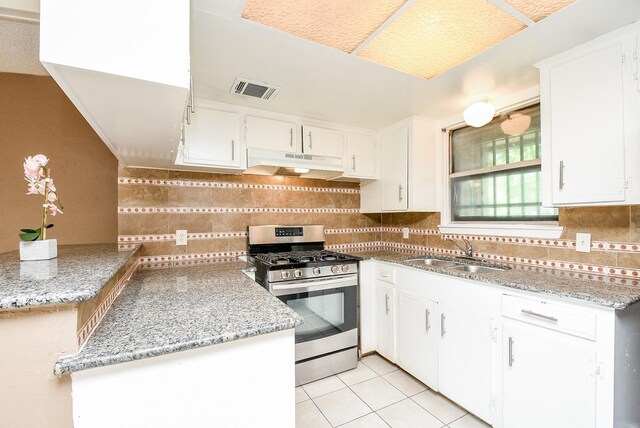 kitchen with sink, stainless steel gas stove, backsplash, and light tile patterned floors