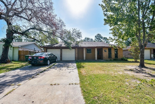 ranch-style house featuring brick siding, a front yard, fence, a garage, and driveway