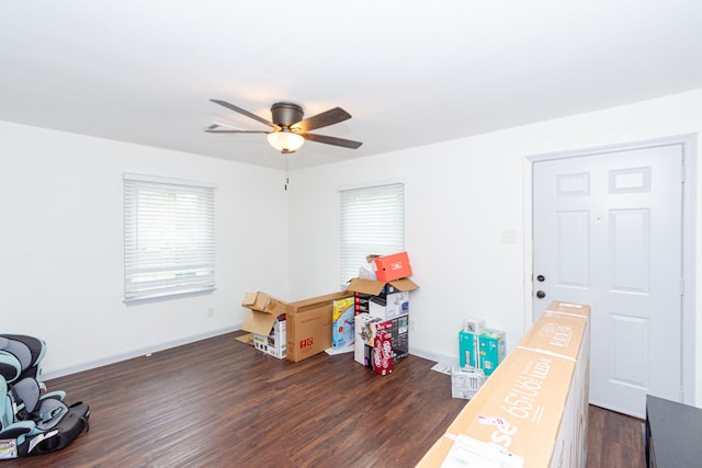 misc room with dark wood-type flooring and ceiling fan