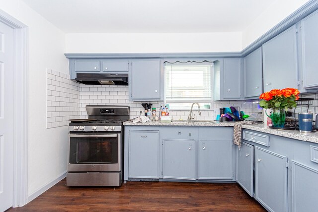 4606 Sharon St, Houston, TX 77020 - kitchen with under cabinet range hood, gas stove, a sink, dark wood-style flooring, and backsplash