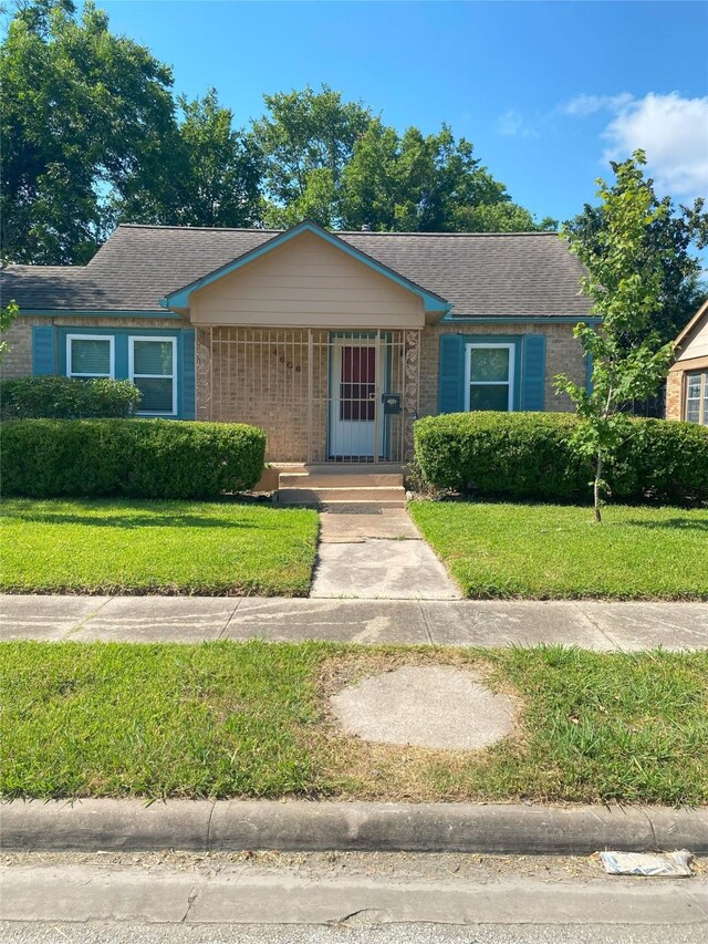 4606 Sharon St, Houston, TX 77020 - view of front of property featuring roof with shingles, a front yard, and brick siding