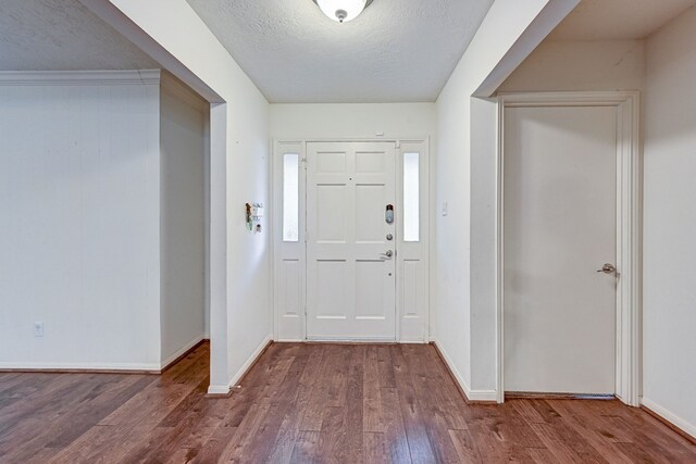 foyer entrance featuring wood-type flooring and a textured ceiling