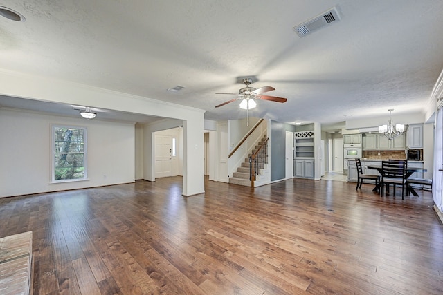 unfurnished living room featuring a textured ceiling, hardwood / wood-style flooring, ceiling fan with notable chandelier, and crown molding