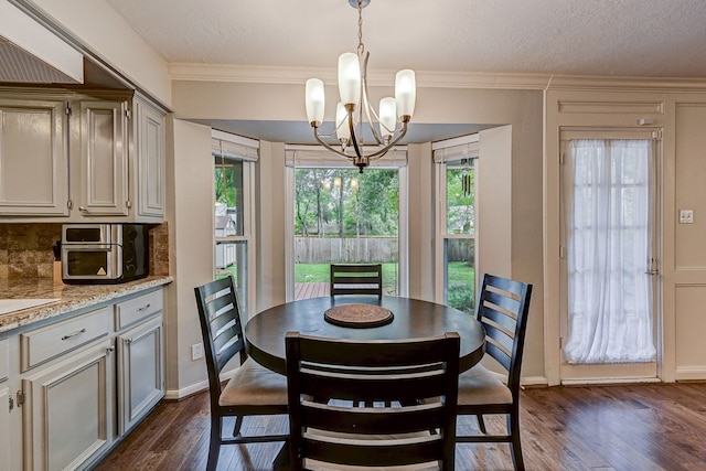 dining room featuring a notable chandelier, dark wood-type flooring, a textured ceiling, and crown molding