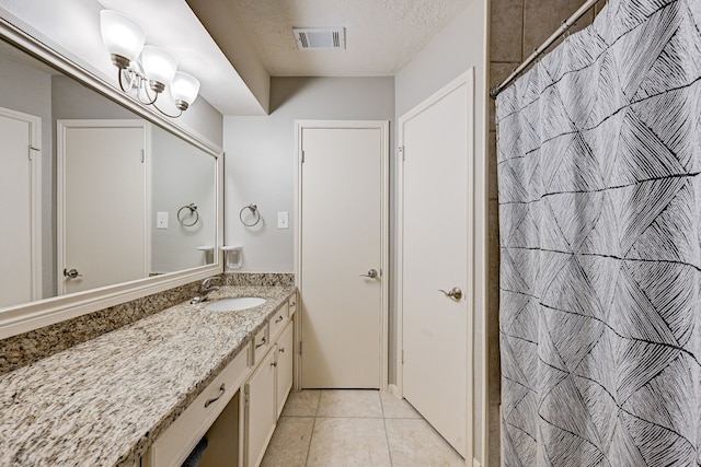 bathroom featuring a textured ceiling, vanity, and tile patterned flooring