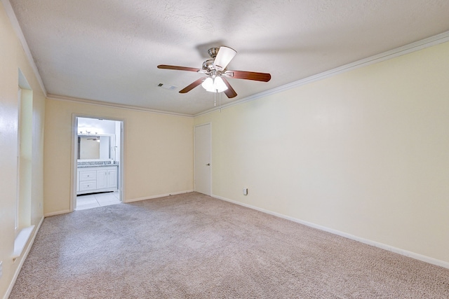 carpeted empty room featuring ceiling fan, a textured ceiling, and ornamental molding