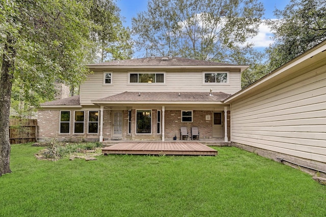 rear view of house with a deck and a lawn