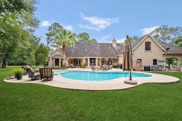 view of pool featuring central AC, a patio, and a lawn