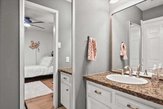 9819 Crestwater Cir, Magnolia, TX 77354 - ensuite bathroom featuring vanity, ceiling fan, and wood finished floors