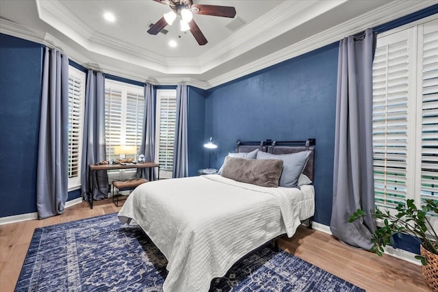 9819 Crestwater Cir, Magnolia, TX 77354 - bedroom with a tray ceiling, wood finished floors, crown molding, baseboards, and a ceiling fan
