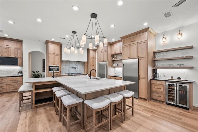 9819 Crestwater Cir, Magnolia, TX 77354 - kitchen with stainless steel appliances, wine cooler, open shelves, a sink, and decorative backsplash