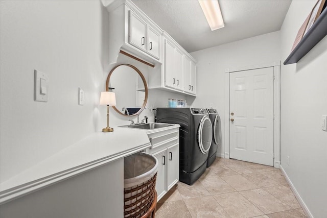 washroom with cabinets, washing machine and dryer, light tile patterned flooring, and a textured ceiling