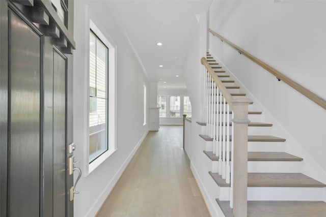 hallway with light hardwood / wood-style flooring and elevator