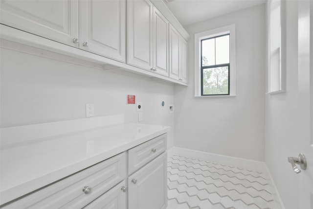 laundry room with cabinets, hookup for an electric dryer, and light tile patterned floors