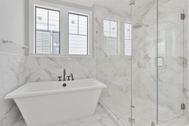 bathroom featuring tile walls, tile patterned flooring, and a healthy amount of sunlight