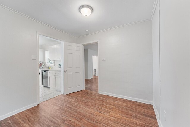 empty room featuring light tile patterned flooring and crown molding