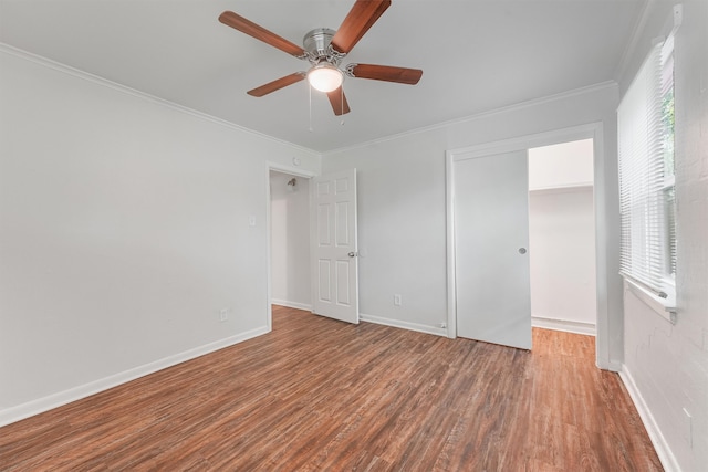 unfurnished bedroom with a closet, wood-type flooring, ornamental molding, and ceiling fan