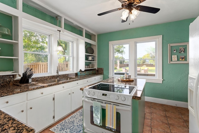 kitchen featuring white cabinetry, sink, electric range, and a healthy amount of sunlight