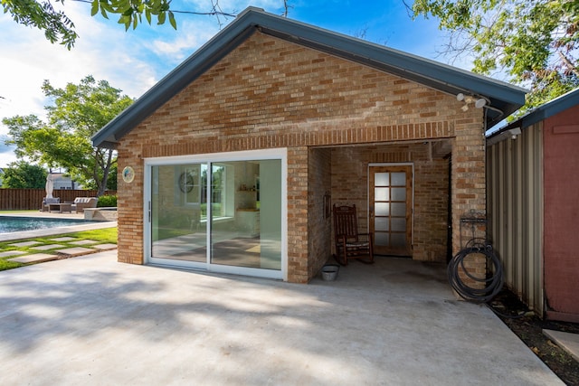 rear view of house featuring an outbuilding and a patio area