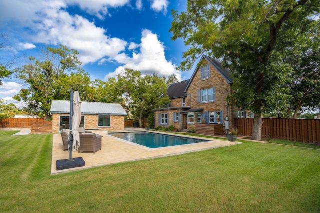 view of pool featuring an outdoor structure, a patio, and a lawn