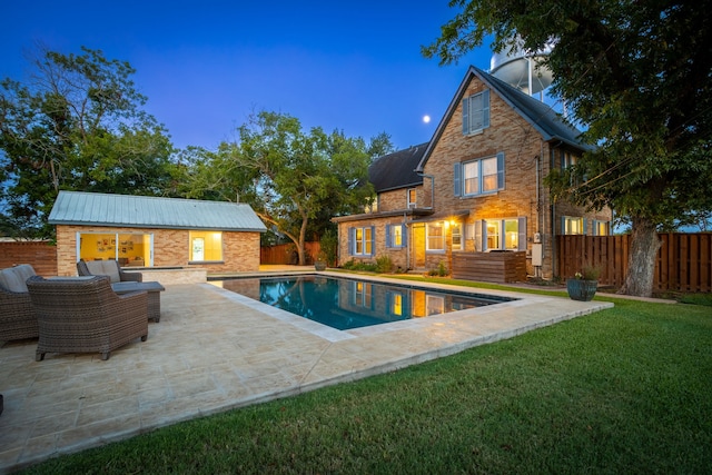 pool at dusk with an outdoor hangout area, a yard, an outdoor structure, and a patio