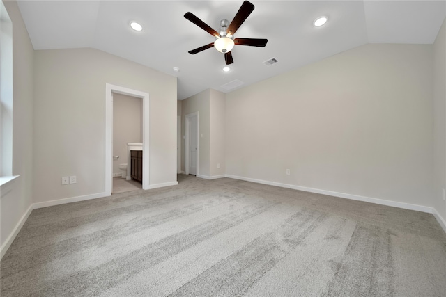 unfurnished bedroom featuring vaulted ceiling, light carpet, ceiling fan, and ensuite bath