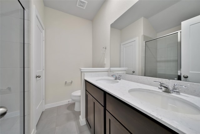 bathroom featuring tile patterned flooring, vanity, a shower with shower door, and toilet