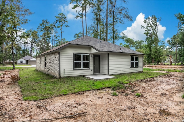 back of property with a patio area and a lawn