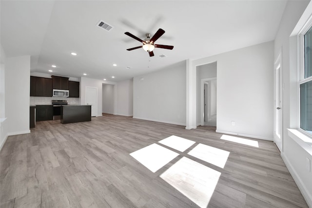 unfurnished living room featuring ceiling fan and light hardwood / wood-style flooring