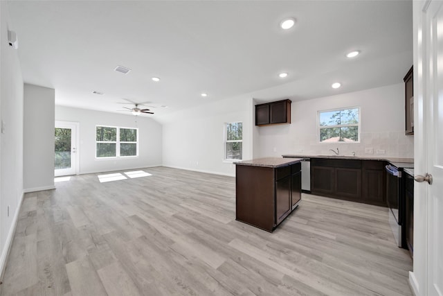 kitchen featuring ceiling fan, dark brown cabinets, tasteful backsplash, a kitchen island, and light wood-type flooring