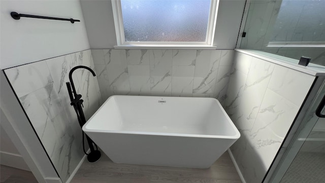 bathroom with hardwood / wood-style flooring and a bathing tub