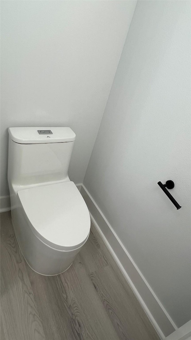 bathroom with hardwood / wood-style flooring and toilet