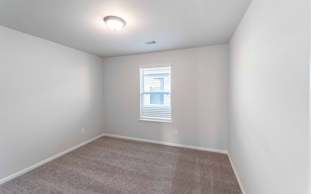 spare room with carpet and a textured ceiling