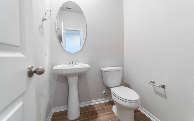 bathroom with wood-type flooring and toilet