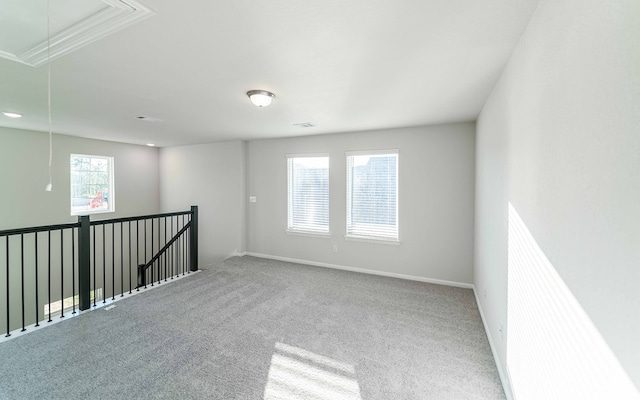 unfurnished room with ornamental molding, carpet floors, and plenty of natural light