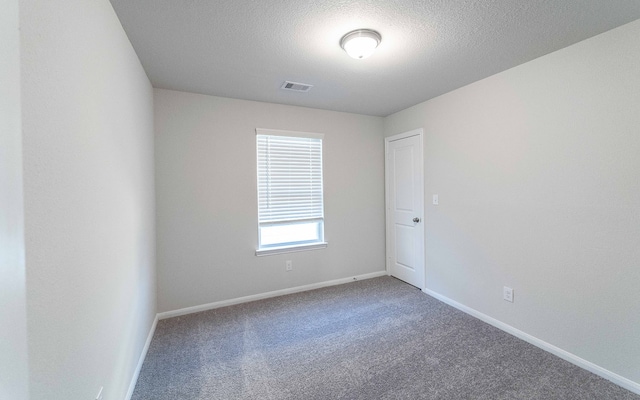 carpeted spare room featuring a textured ceiling