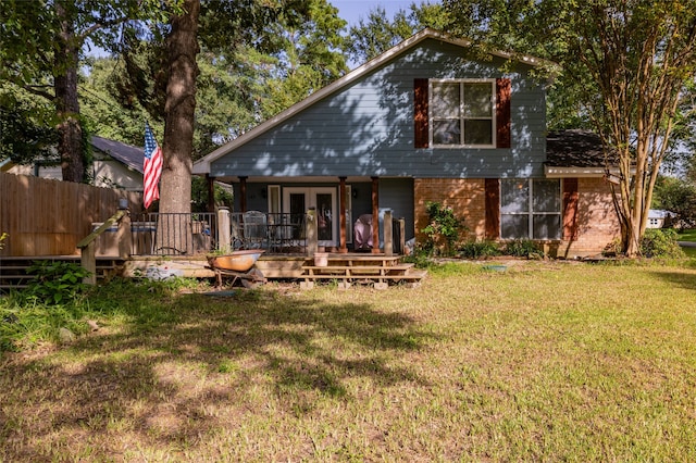 back of house with a wooden deck, a yard, and french doors