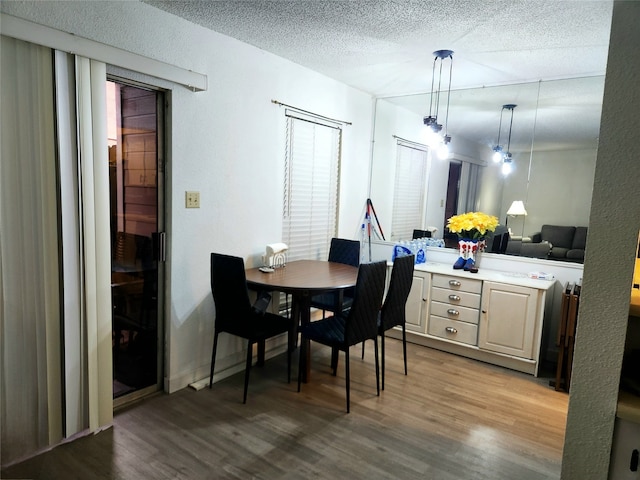 dining room with hardwood / wood-style flooring and a textured ceiling