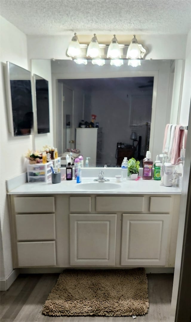 bathroom with vanity, a textured ceiling, and wood-type flooring