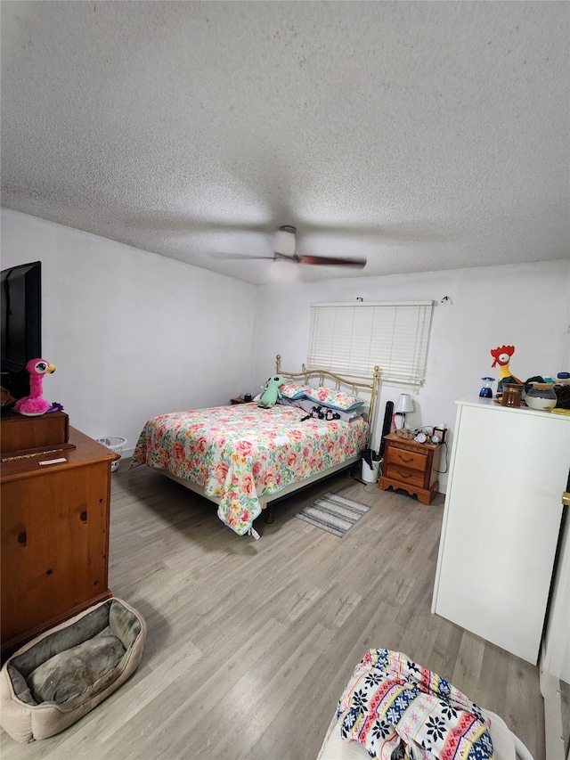 bedroom with light hardwood / wood-style floors, a textured ceiling, and ceiling fan