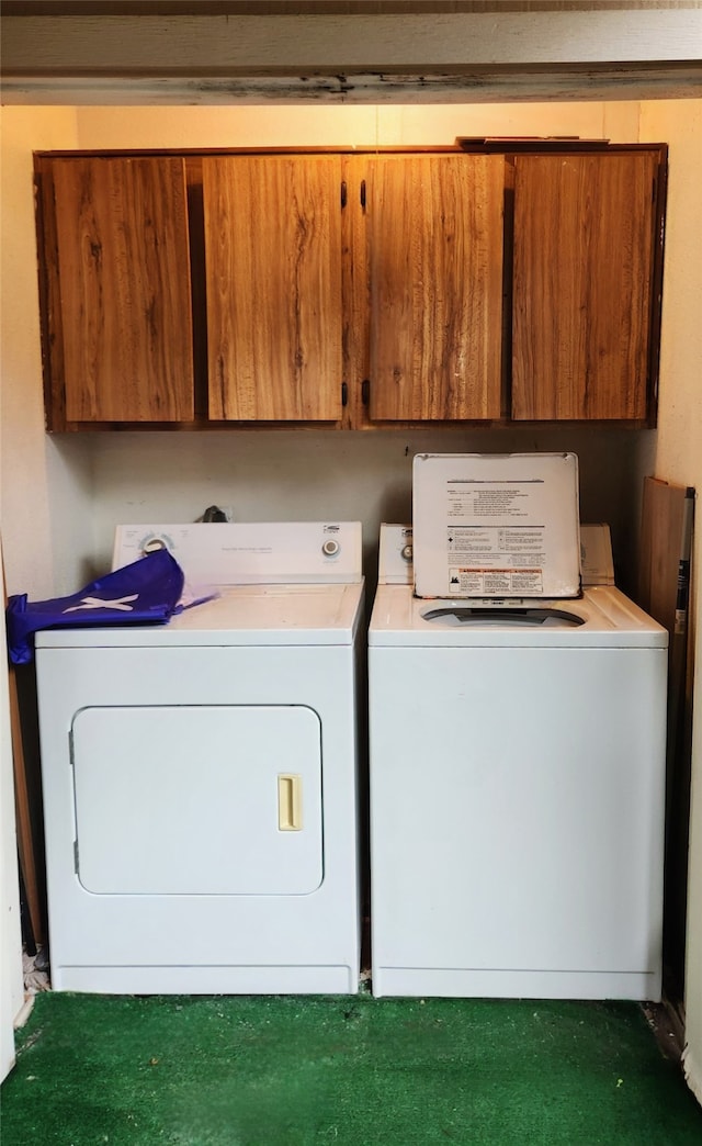 laundry area with washing machine and clothes dryer and cabinets