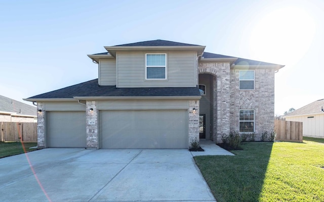 traditional-style home with a front yard, fence, driveway, and an attached garage