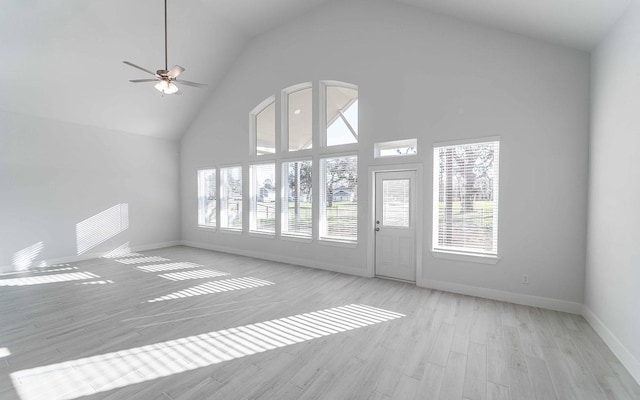 unfurnished living room featuring high vaulted ceiling, ceiling fan, baseboards, and wood finished floors