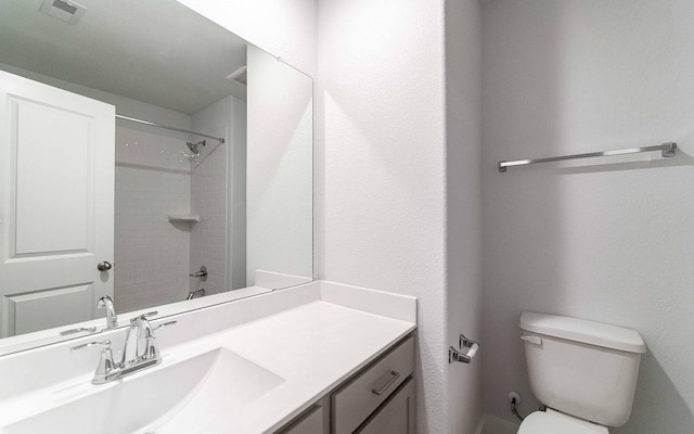 bathroom with toilet, visible vents, walk in shower, and vanity