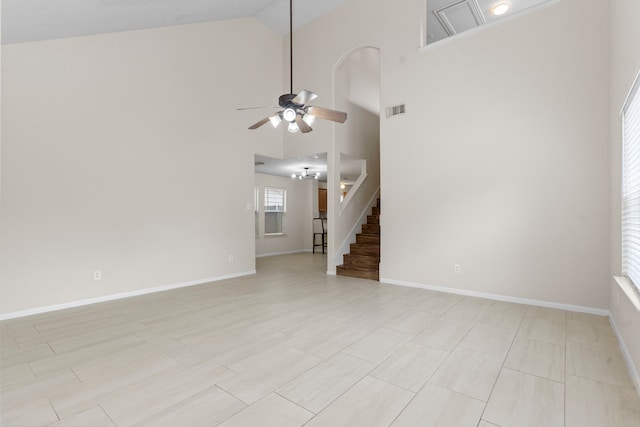 unfurnished living room with stairway, high vaulted ceiling, ceiling fan, baseboards, and visible vents