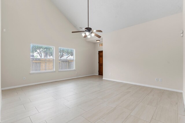unfurnished room with baseboards, a ceiling fan, and high vaulted ceiling