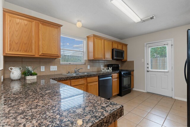 kitchen with black appliances, sink, light tile patterned floors, and backsplash